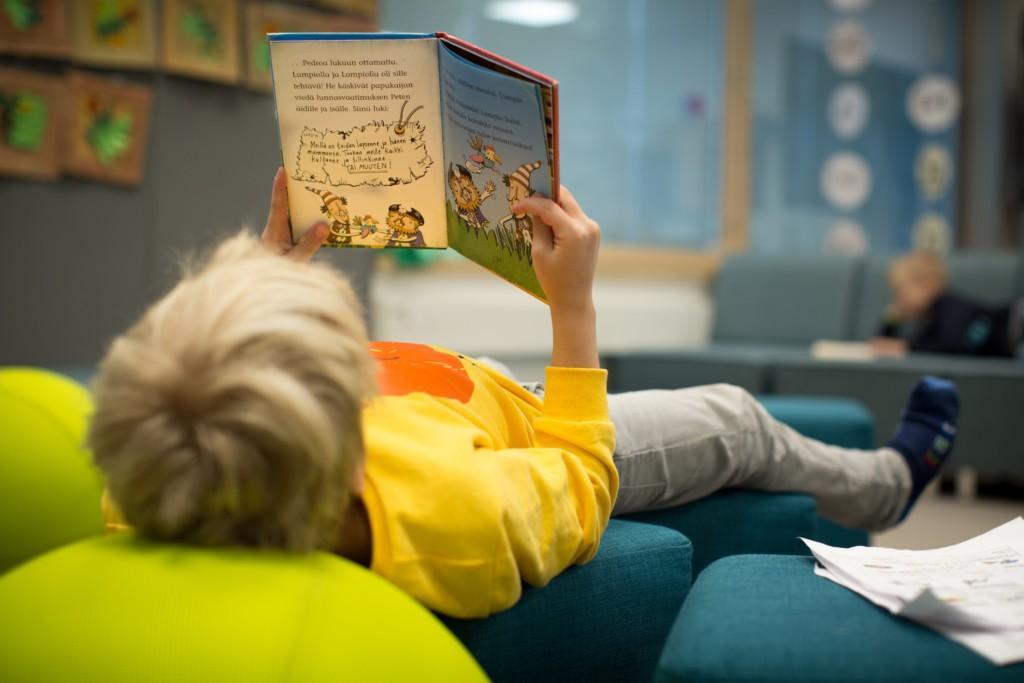 En pojke läser en bok.