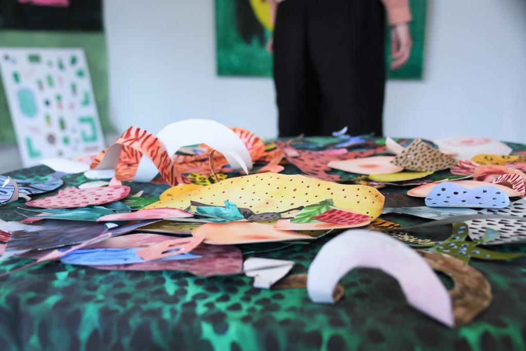 Erimuotoisia ja värisi papereita pöydällä taidenäyttelyssä