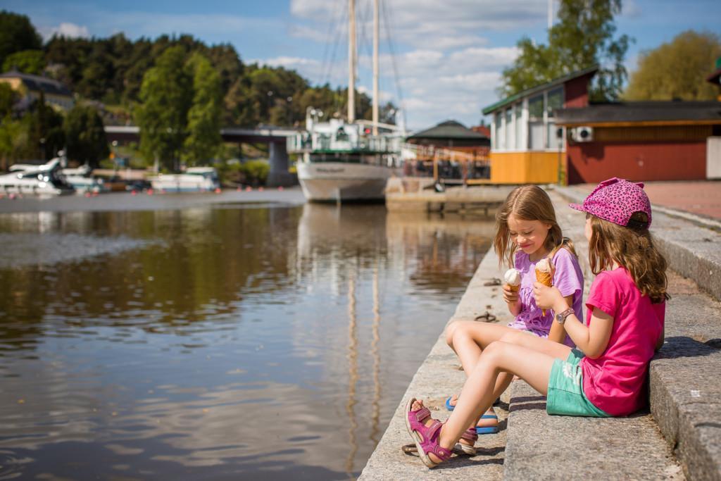 Kaksi tyttöä istuu jokirannassa.