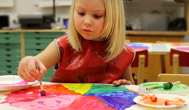 Kuvismuskarin oppilas maalaa väriympyrää