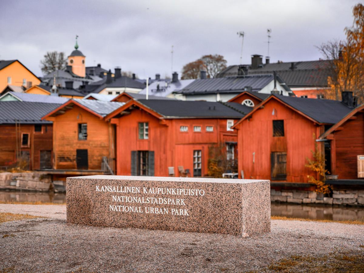 Byggnader i Gamla Borgå i bakgrund, och stenen med rubrik Nationalstadspark framme i bilden.