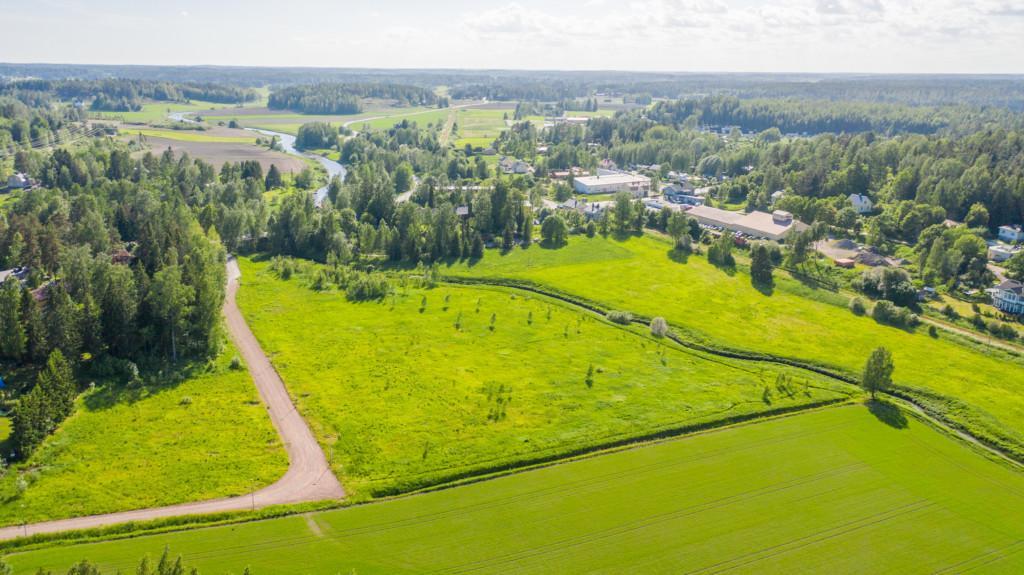 Flygbild över Carlandersvägens småhusområde före det finns hus på området samt omgivande landskap.