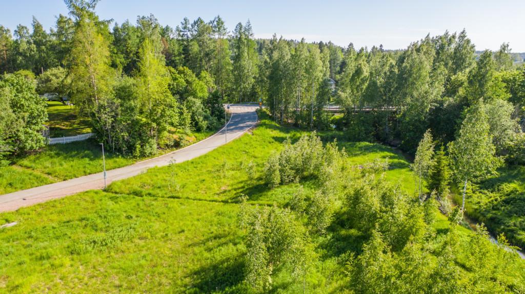 Flygbild över Carlandersvägens småhusområde före det finns hus på området samt omgivande landskap.