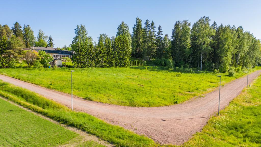 Flygbild över Carlandersvägens småhusområde före det finns hus på området samt omgivande landskap.