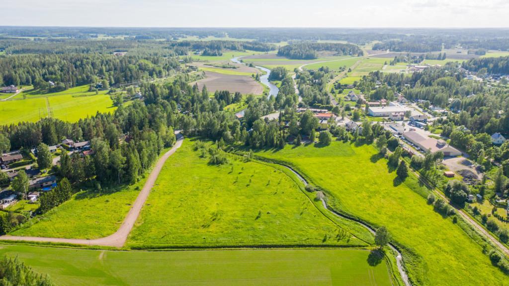 Flygbild över Carlandersvägens småhusområde före det finns hus på området samt omgivande landskap.