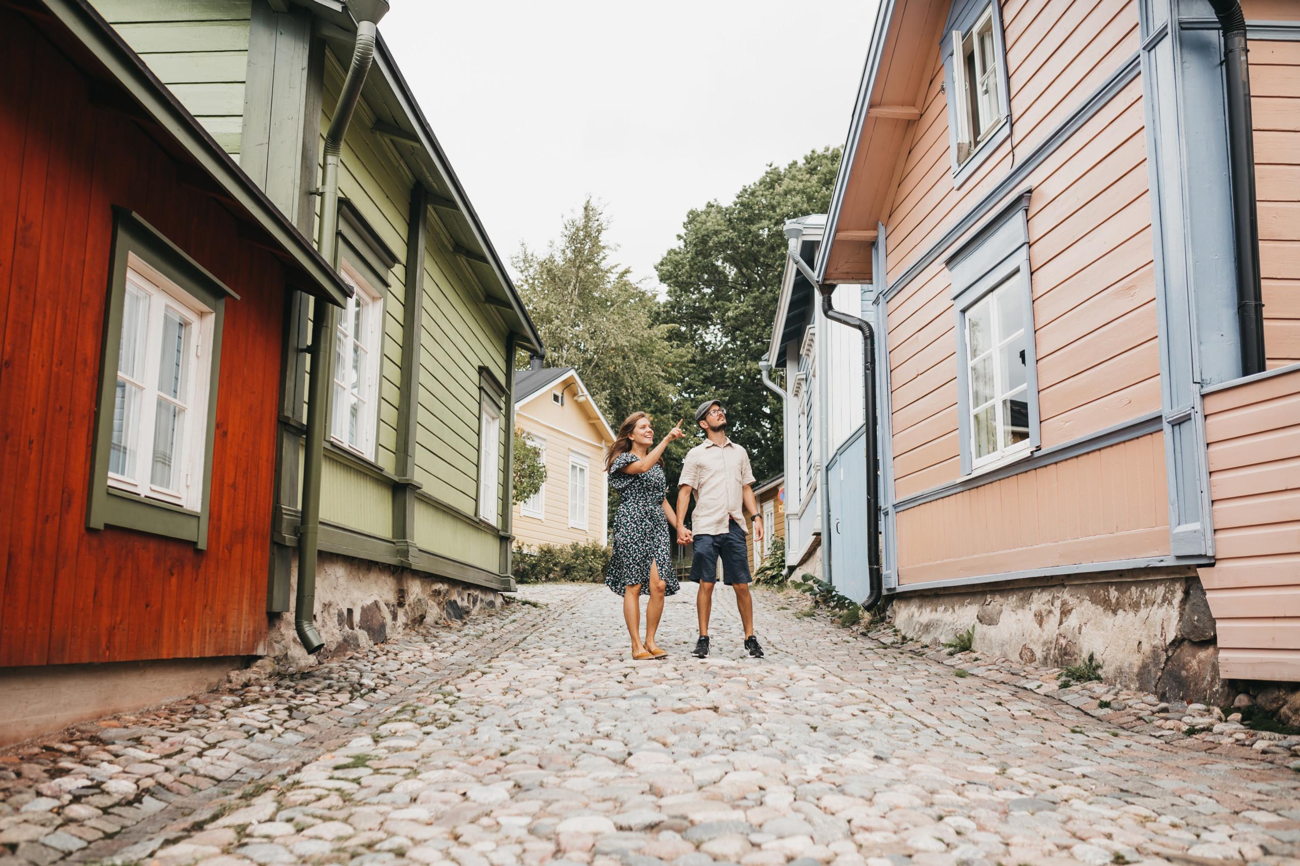 A couple holding hands on a narrow street in Old Porvoo.