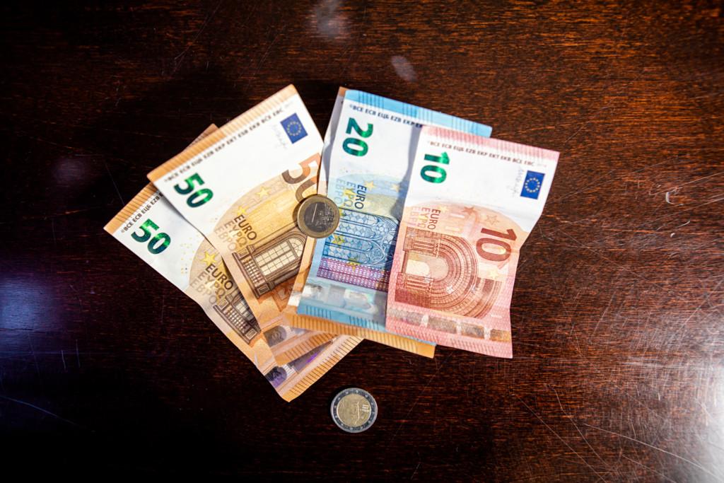 Pöydällä kaksi viidenkymmenen euron seteliä, yksi kahden kymmenen euron seteli ja kymmenen euron seteli.