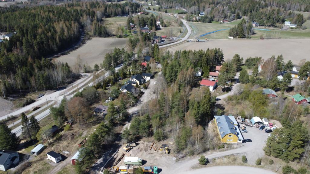 Ilmakuva Suomenkylästä. Keskellä pieni metsäsaareke ja tasoitettu hiekkakenttää, mihin uudet tontit tulevat. Ympärillä on omakotitaloja 1900-luvun alkupuolelta 2000-luvun alkuun. Kauempana peltoja ja metsiä.