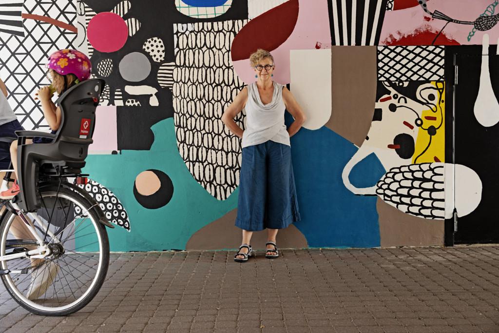 en person står framför en mural. Ylva Holländer, Galleri Gata, Borgå 2021