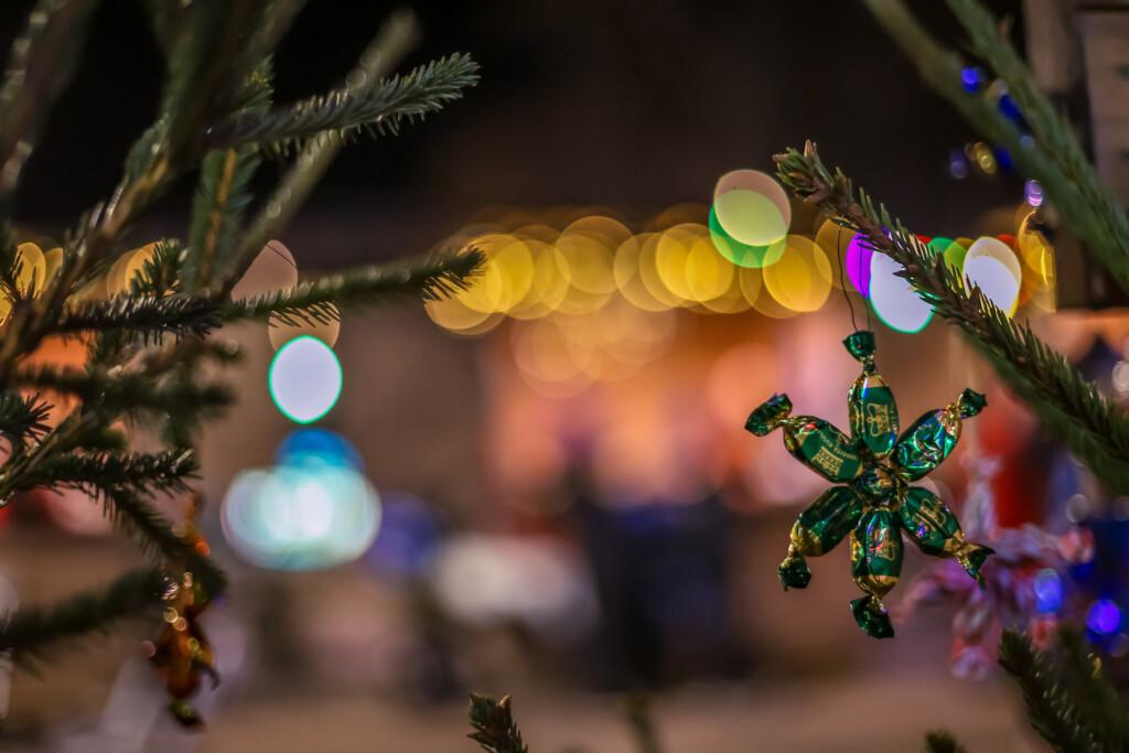 Christmas ornaments and market stall lights in the background.