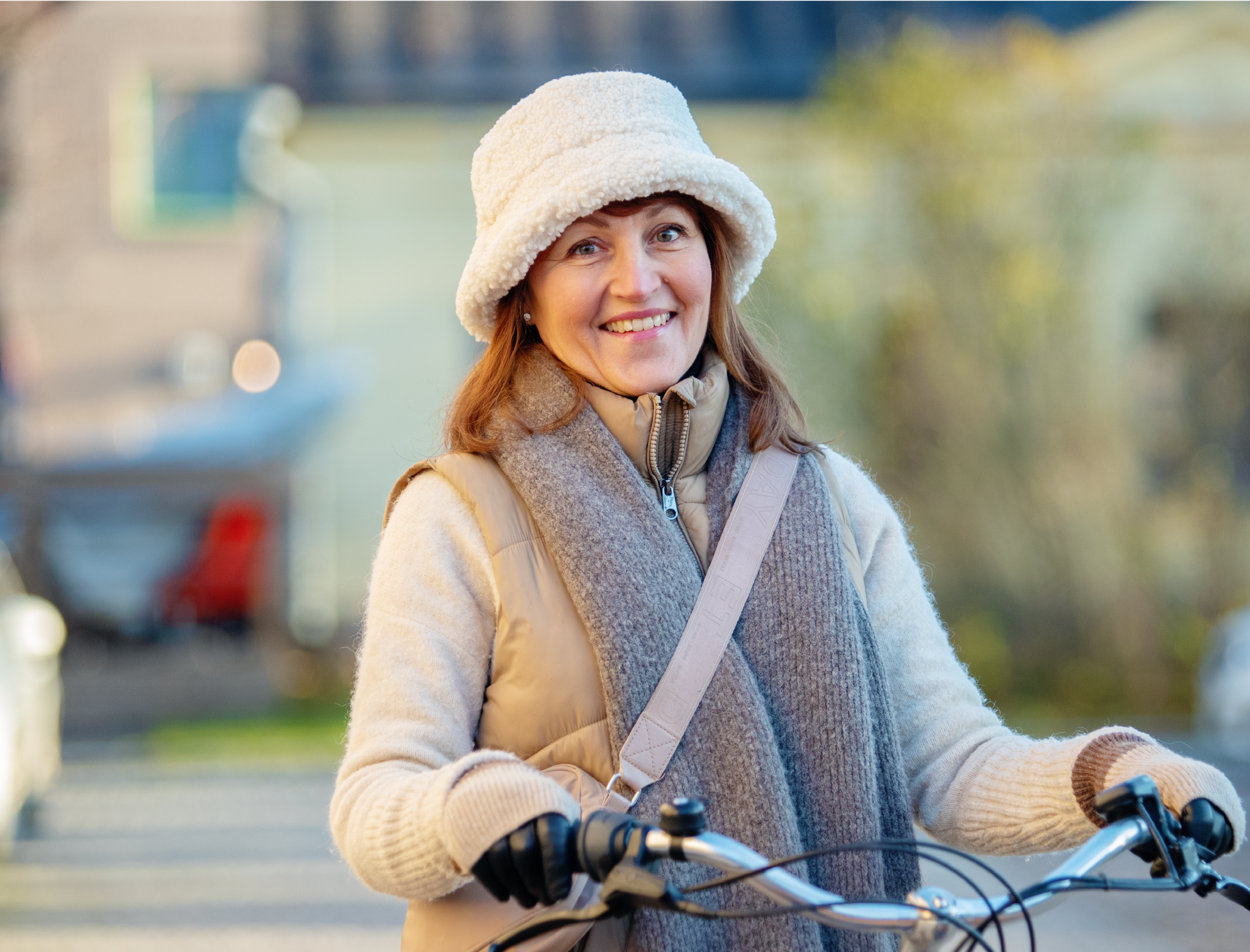 Hymyilevä nainen polkupyörän kanssa.