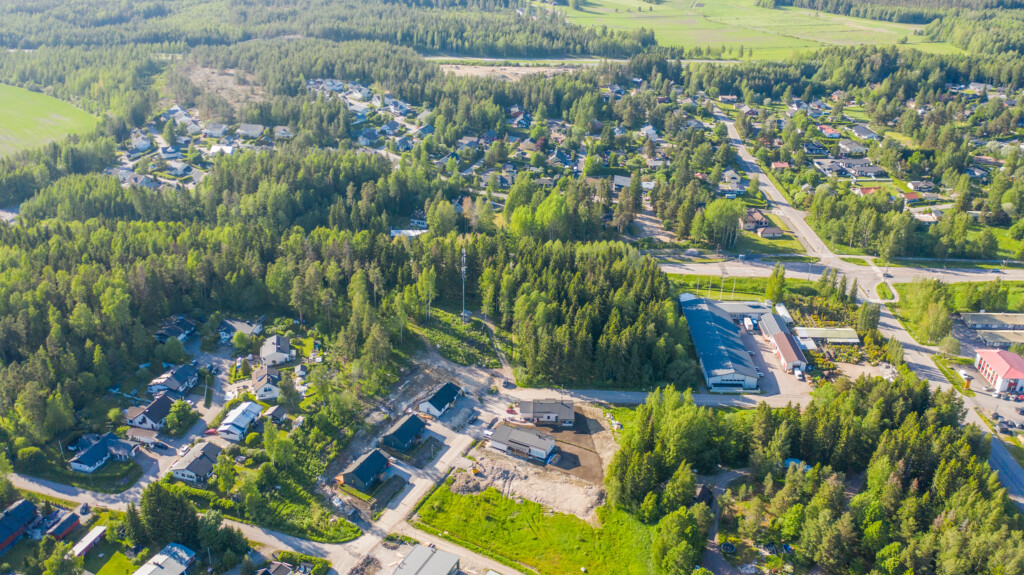 Ilmakuva Raivaajantie 10:n tonteista omakotivaltaisen asuinalueen laidalla. Lähellä näkyy yritystontteja, vähän kauempana on metsä- ja peltomaisemaa.