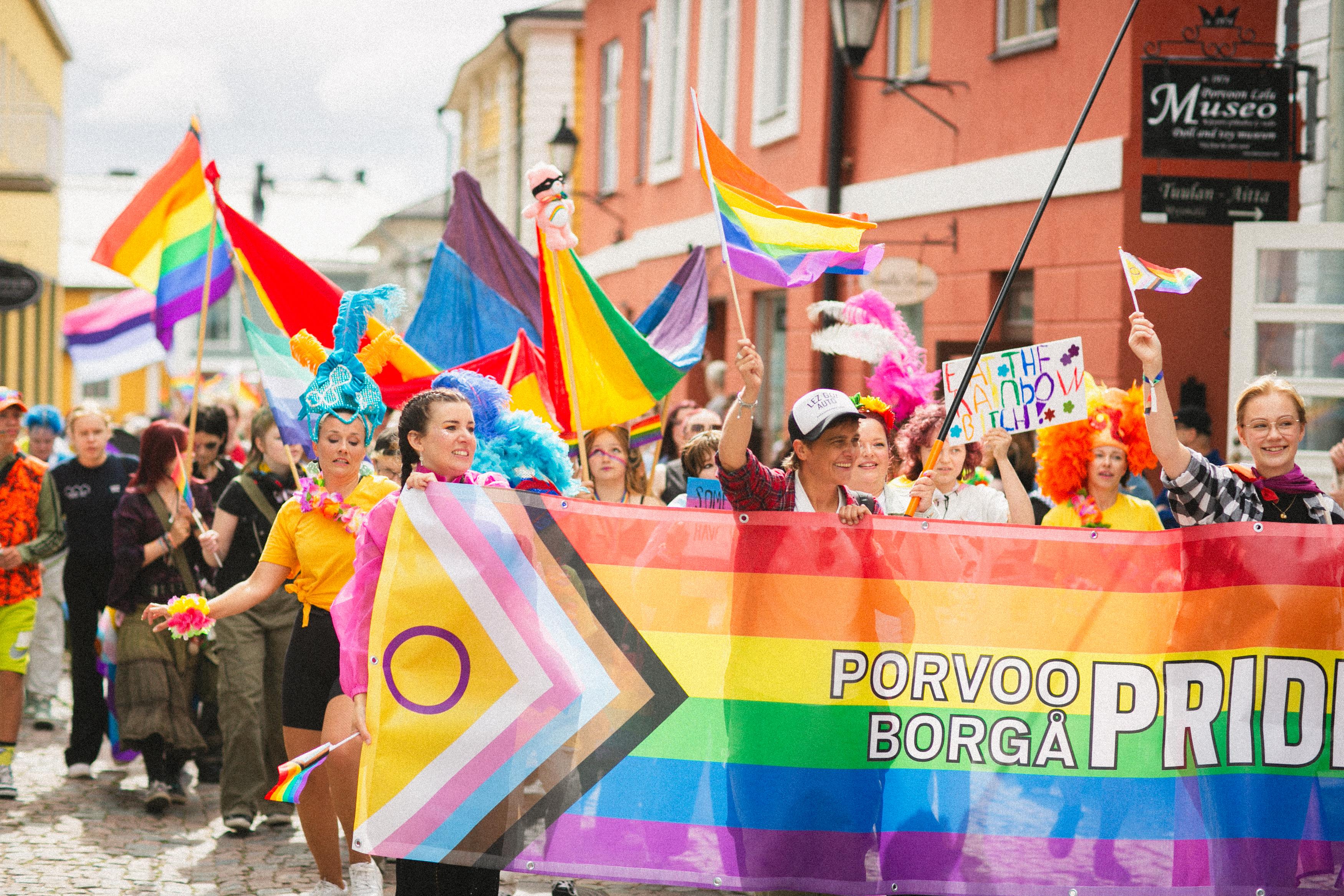 Porvoo Pride -kulkueessa paljon väkeä ja sateenkaarilippuja.
