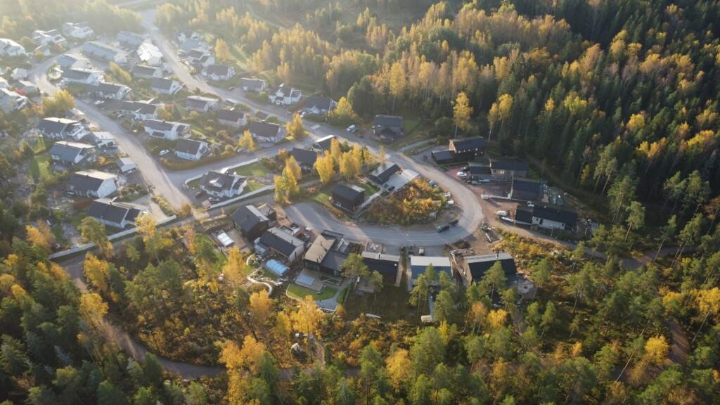 Ilmakuva, omakotitaloja ja muutama tyhjä tontti metsän ympäröimällä alueella.