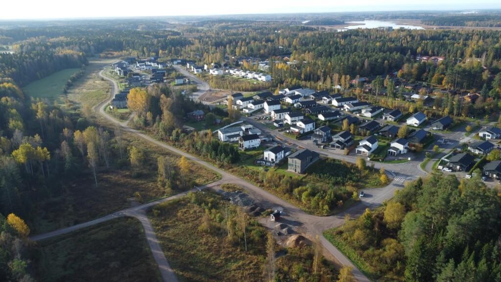 I mitten av flygfotot syns ett bostadsområde med främst egnahems- och parhus. På östra sidan finns skog och en öppen äng, medan äldre hus skymtar mellan träden på västra sidan.