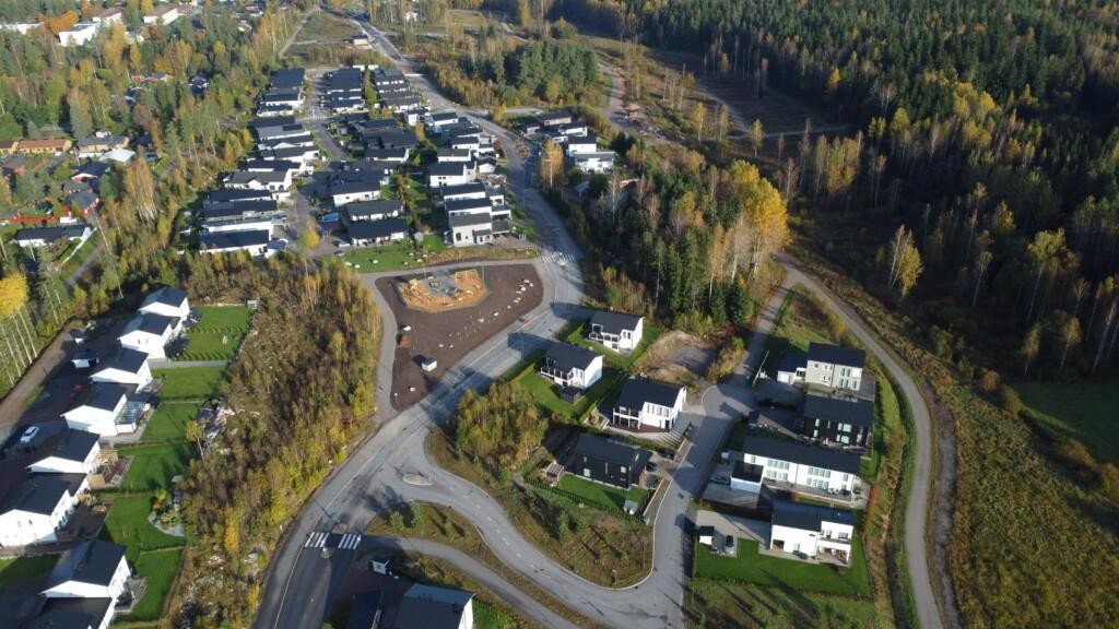 Flygfoto över det egnahems- och parhusdominerade bostadsområdet Vårdalen. I mitten syns en ny lekpark.