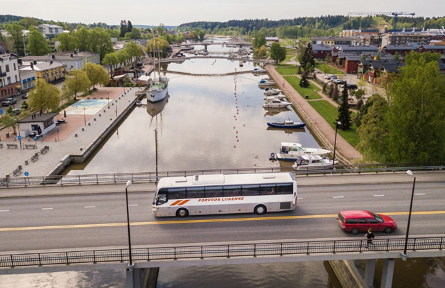 Buss kör på bron över ån.