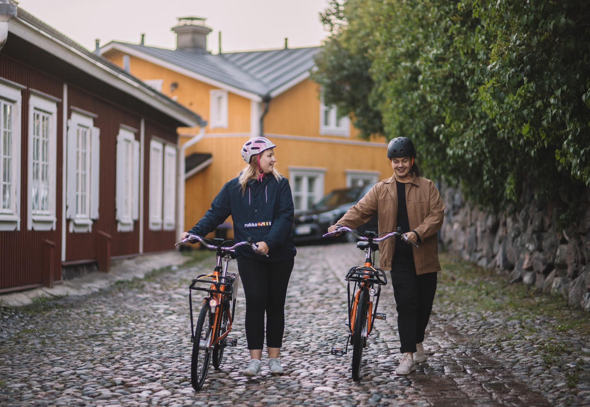 Kaksi nuorta taluttaa pyöriä Vanhassa Porvoossa.