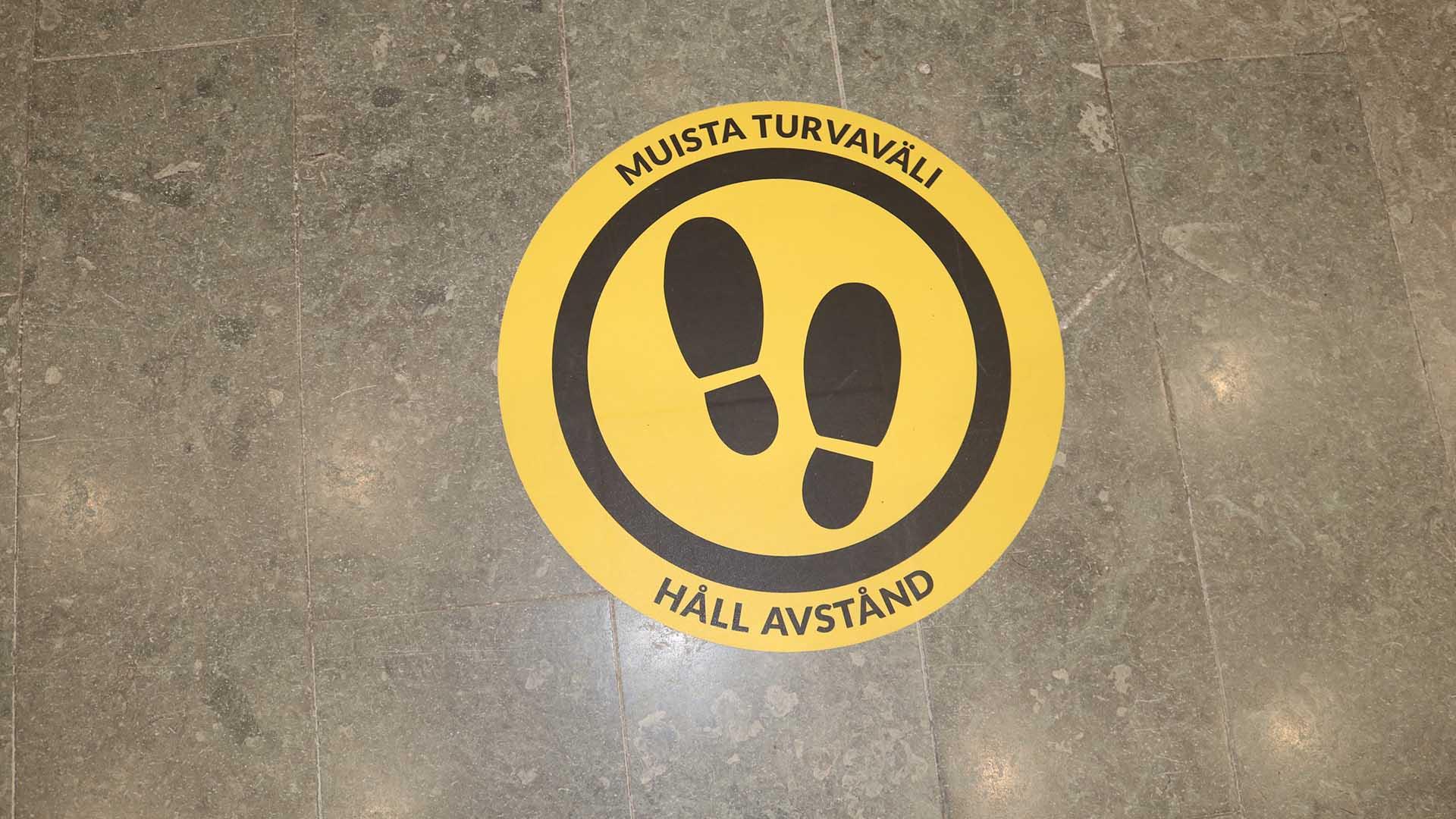 Lattiassa on tarra, jossa lukee muista turvaväli, håll avstånd.