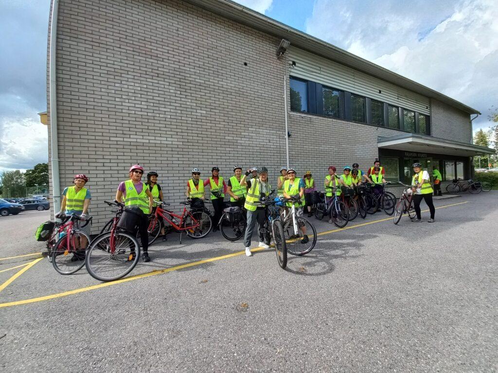 Pyöräilijöitä kirjastorakennuksen edustalla.