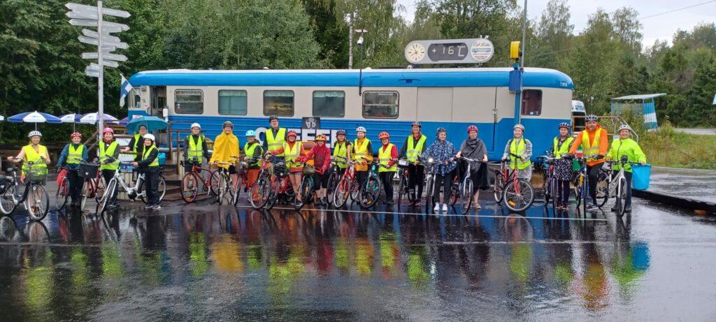 Pyöräilijöitä junanvaunun edustalla.