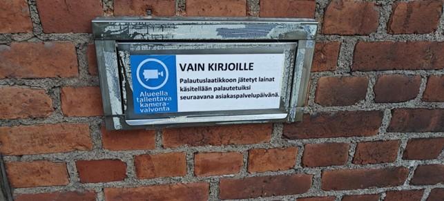 Palautusluukku tiiliseinässä.