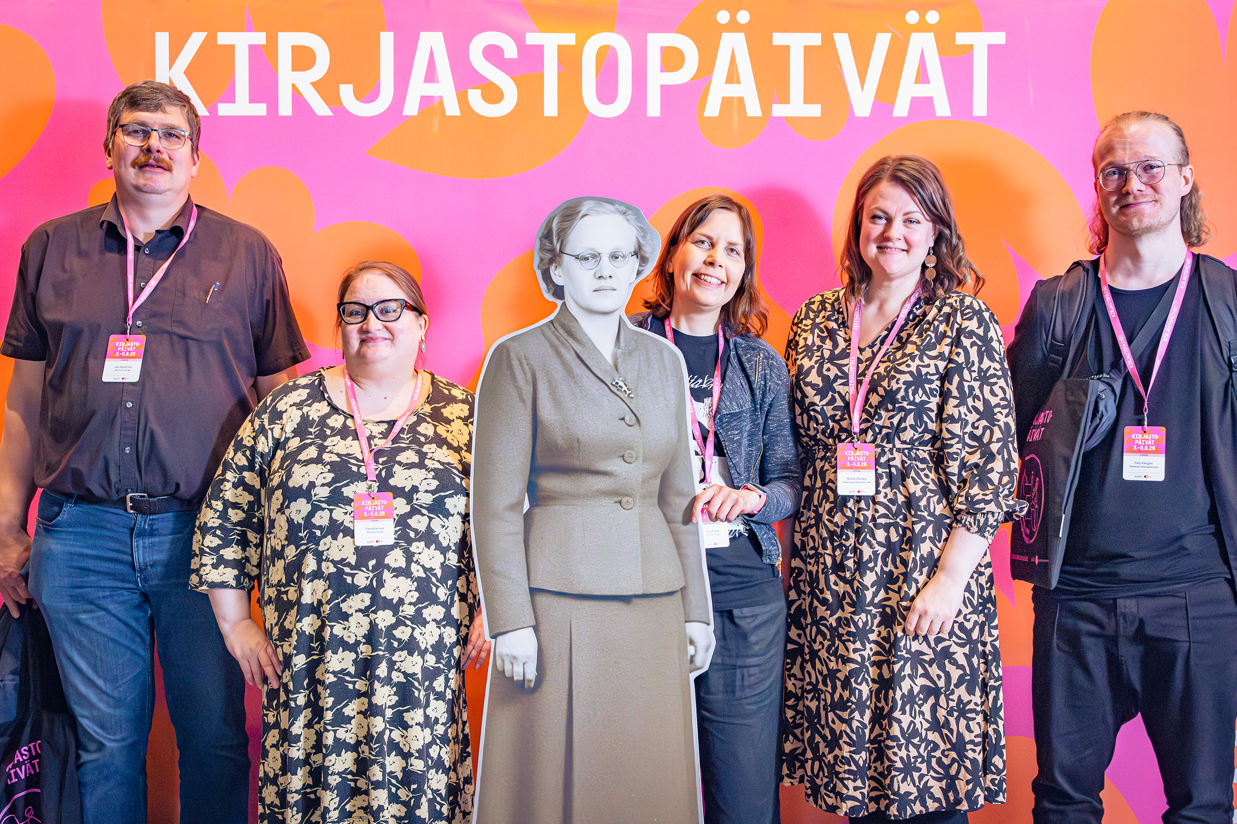 Viisi henkilöä ja yksi pahvifiguuri Kirjastopäivät-kyltin edessä.