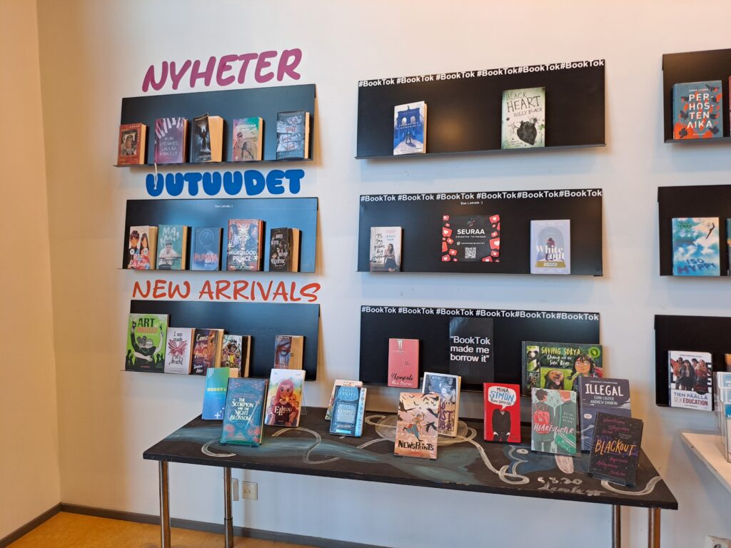 Hyllyissä ja pöydällä esillä uutuuskirjoja sekä BookTok-vinkkejä suomeksi, ruotsiksi ja englanniksi.