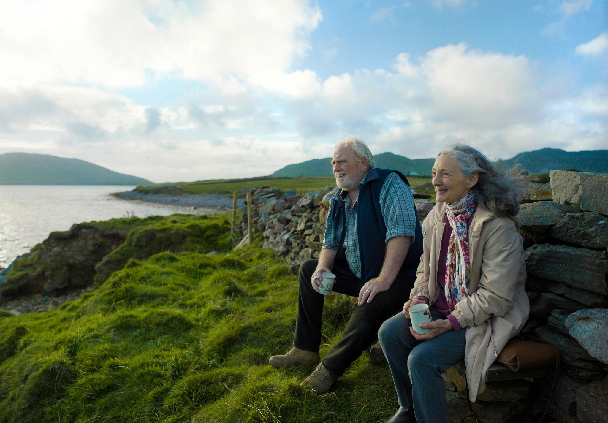 Kaksi ihmistä istuu meren äärellä ja katsoo maisemaa. Kuva on Klaus Härön elokuvasta Rakkaani merikapteeni.