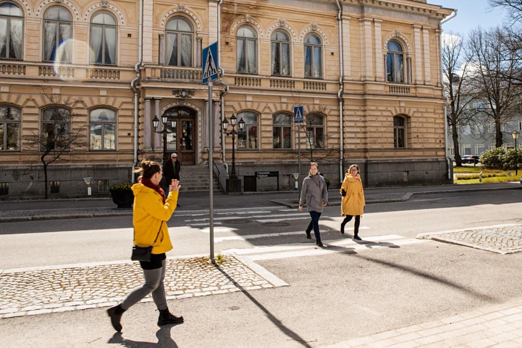 Kolme naista kävelee kaupungintalon edustalla.
