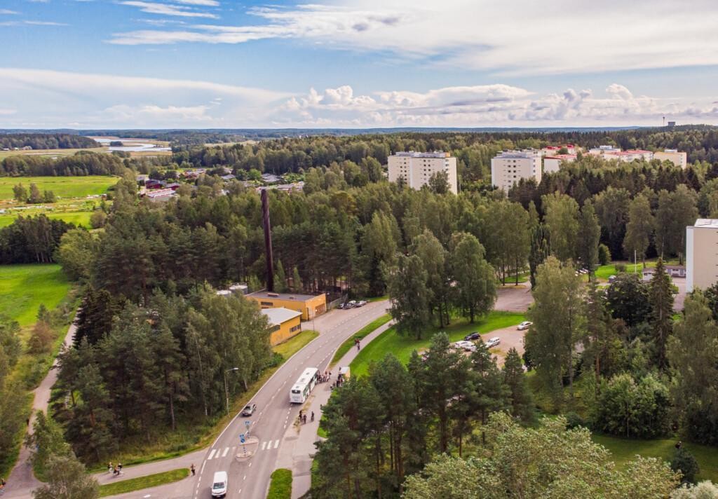 Porvoon bussi pysähtyy yläkoulun pysäkille. Kadun varrella on metsää ja taustalla näkyy kerrostaloja.