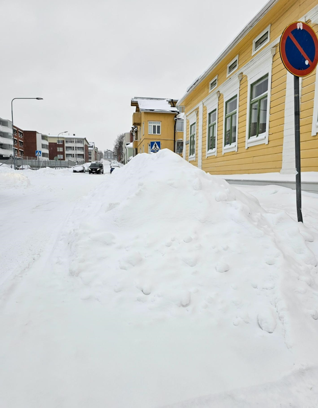 Lumikasa kiinteistöjen edessä.