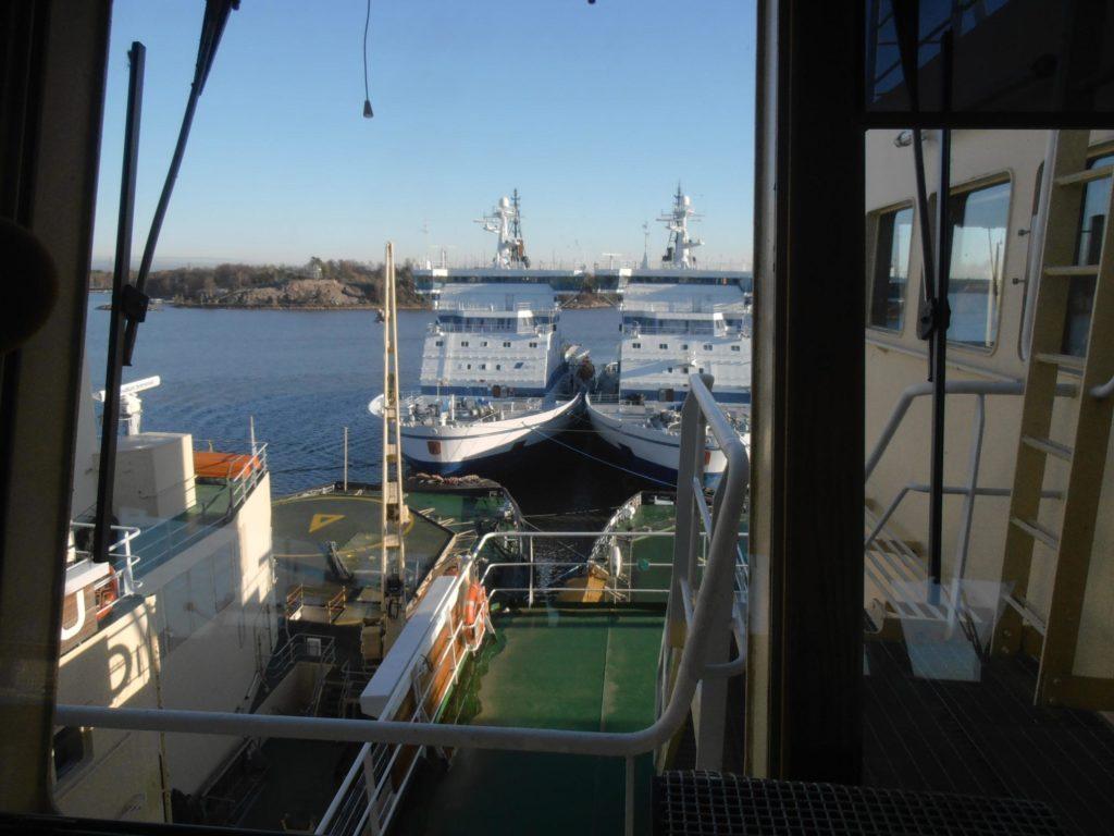 A picture onboard a vessel, with ice breakers behind the vessel.